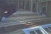 Friends help lift a completed wall into place.